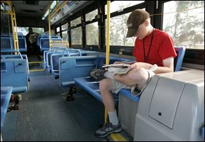 Jake Benjamin reads while waiting for the 2X Sylvania Express to leave the TARTA station on Centennial Road. He takes the 2X to his job on Monroe Street.