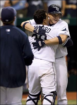 Dioner Navarro, left, of the Tampa Bay Rays, hugs Shawn Riggans after Riggans scored the game-winning run in the 10th inning on a bases-loaded walk against the Detroit Tigers .