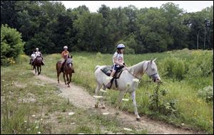 Maggie Jutte, 10, of Bluffton, Ind., at right, enjoys a ride along the 2-mile bridle path at Pokagon State Park in Angola, Ind. 