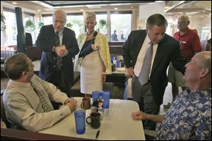 Sen. John McCain, standing with his wife Cindy, center, and Sen. Lindsey Graham (R., S.C.) talk with Steve Boergert, seated left, and Jon Reusch, seated right, during a campaign stop at Kerby's Koney Island diner in Bloomfield Hills, Mich., yesterday. associated press
