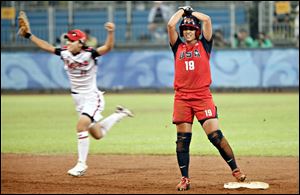 Japan's Eri Yamada celebrates as Victoria Galindo stands stunned on second base after the Americans lost a softball game for the first time since Sept. 21, 2000, at the Sydney Games.