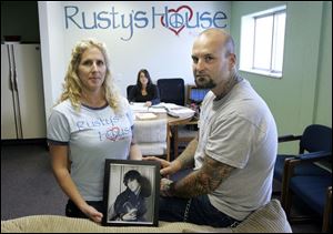Amy and Rick Marvin, with a portrait of their son, Rusty, with their daughter, Hailey Marvin, seated behind them, at Rusty s House. Mr. and Mrs. Marvin established the nonprofit center offering help to those with addictions after Rusty s death.