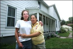Cindy Rybak, left, with her daughter, Alicia, works two jobs to pay the mortgage on the home they share in West Toledo.