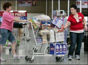 Angie Keween gets a hand with her piled-high cart from Costco employee Kaitlyn Leask on the way to the checkout. 