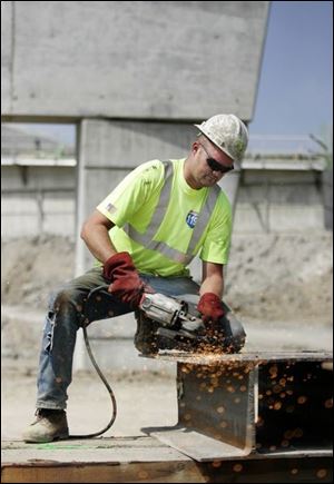 Jody Holly, of Walter Toebe Construction Co. of Wixom, Mich., grinds base mats for support towers at the construction site. 