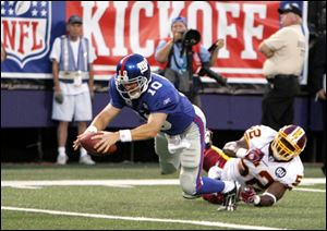 The Giants' Eli Manning dives into the end zone on a naked bootleg before Rocky McIntosh can get to him in the first half.