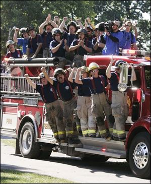 Firefighters participate in the 'Braveheart' march that begins the demolition of Aaron and Jackie Frisch's home.