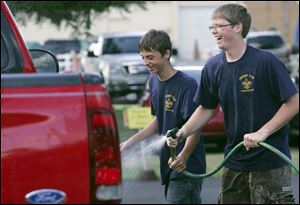 NBRN downtown11p         09/06/2008       Blade Photo/Lori King Members of Scout Troop 770 R.J. Crawford and Josh Davis share laughs and the hose during a charity car wash during annual downtown Temperance Days in Temperance, Mich. Their troop was raising funds for St. Paul's Food Closet.