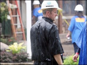 Mr. Schlachter works through rain at the Extreme Makeover site.
