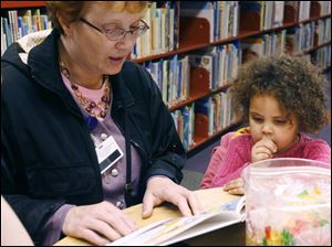 CTY record03p   Anne Norman, left, reads "Corduroy" to her friend Cristine (cq) Moss, 3.5, both of Toledo. The Washington Branch of the Toledo-Lucas County Public Library celebrates Jumpstart's Read for the Record on Thursday, October 2nd in Toledo, Ohio. Staffers and visitors will try to set the world record for the largest shared reading experience ever with crafts, activities, and many readings of "Corduroy" by Don Freeman.  The Blade/Jetta Fraser
