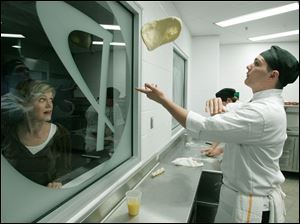 NBRW penta02p   09/28/2008 The Blade/Dave Zapotosky Caption: Linda Irving of Perrysburg watches Jared Koester, 17, of Millbury, Ohio, toss bread dough in the Culinary Connection at the Penta Career Center in Perrysburg, Ohio, during the school's open house Sunday, September 28, 2008.  Lake High School is Koester's home school. Summary: Open house at the Penta Career Center.