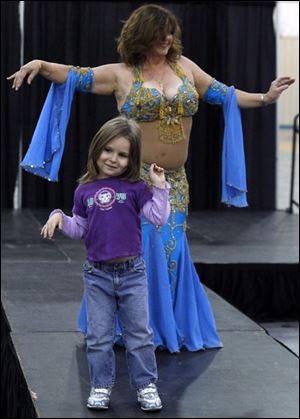 Slug: NBRW expo09p B                            The Blade/Jeremy Wadsworth  Date: 10/04/08  Caption: Chloe Munoz, 4, of Sylvania learns the finer point of belly dancing from Aegela during the Women's Expo Saturday, 10/04/08, at Tam-O-Shanter in Sylvania, Ohio.