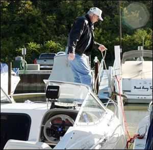Don Pelchat of Holland unties his boat and prepares to tow it from the Rossford Marina with some assistance from Joe Jarvis of Perrysburg. 
