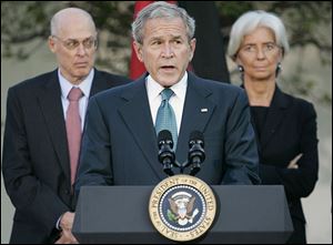 President Bush pauses during a press conference with the G7 Finance Ministers in the Rose Garden of the White House Saturday, Oct. 11, 2008, in Washington. At back left is Treasury Secretary Henry Paulson and French Finance Minister Christine Lagarde, right. 