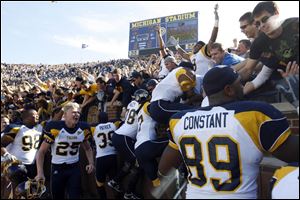 University of Toledo players climb into the stands at Michigan Stadium yesterday to celebrate with Rocket fans after the team's victory over Michigan. 
<br>
<img src=http://www.toledoblade.com/graphics/icons/photo.gif> <font color=red><b>VIEW</font color=red></b>: <a href=