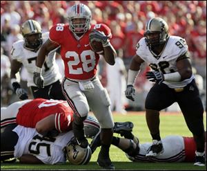Chris 'Beanie' Wells blasts through a hole for some of his 94 yards. He was Ohio State's leading rusher yesterday.