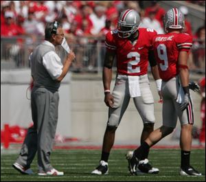 OSU coach Jim Tressel gives instructions for the next play to Terrelle Pryor (2) and Brian Hartline to take into the huddle. (THE BLADE/LORI KING)
<br>
<img src=http://www.toledoblade.com/assets/gif/weblink_icon.gif> <b><font color=red>HEY, WOLVERINES-BUCKEYES FANS:</b></font color=red> Check out <a href=