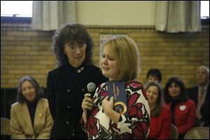 Stacia Timmons Higgins speaks to the audience in the gym at Ridge Elementary as Jane Foley of Los Angeles looks on.
