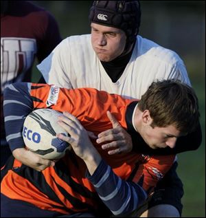 Ian Robertson wraps an arm around Jonas Kloos during a practice last week. The team plays home games at Sterling Park.