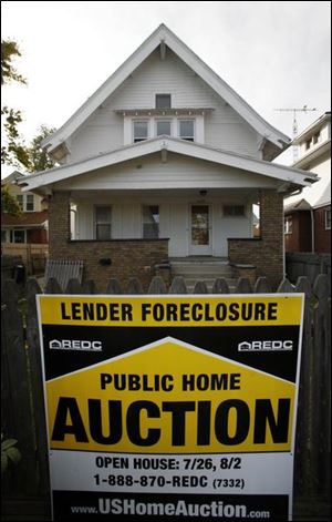 A foreclosure sign posted at 1176 Broadway is one of many locally.