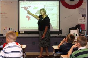 Jeanne Hufford says she uses the interactive board in her classroom four out of six hours each day as a way to balance educational standards and keep the attention of her third graders.