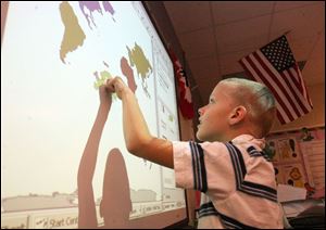 Third grader Philip Zaborski uses the Smart board at Ottawa River Elementary School.