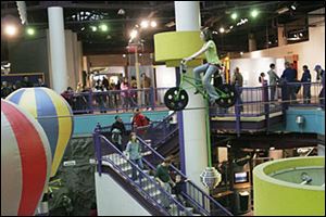 Isabella Frownfelter, 11, of Flint, Mich., takes the high-wire bicycle for a whirl during COSI s last day of operation in December, 2007. The downtown science museum has remained closed.
