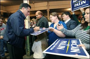 Former presidenital hopeful Mitt Romney signs autographs during an appearance Sunday night in Toledo.