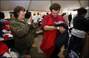 Tent City Mayor Michele Ross helps Jason Jock find a sweatshirt in his size during the three-day event on the Civic Center Mall.