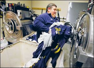 UT Football equipment manager Rusty Rogers does a load of laundry as part of preparations for the next day s practice.