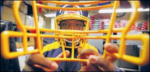 University of Toledo football player Tyson Patrick, Jr., chooses a face mask after he is issued a new helmet.