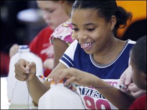 Slug: NBRN music13p Date:  11/04/2008        The Blade/Andy Morrison       Location:   Monroe  Caption: Jasmine Hutchins, 12, has fun as she and other children make shekeres, a Nigerian instrument, as part of Musical Instruments Around the World program at L.S. Navarre Library Branch in Monroe, Wednesday, 11/05/2008. Summary: