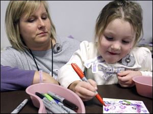 Slug: CTY nicu13p C                                        The Blade/Jeremy Wadsworth  Date: 11/012/08  Caption: Paula  Samples, NICU nurse, helps her daughter Madison, 4, decorate a tile during a reunion for  patients of the St. Vincent's Children's Hospital Newborn Intensive Care Unit (NICU) that helped mark Prematurity Awareness Day Wednesday, 11/12/08, in Toledo, Ohio.