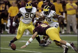 Minnesota quarterback Adam Weber dives to recover a fumble as he beat Michigan's Tim Jamison (90) and Brandon Graham (55) to the loose ball in the second quarter Saturday.