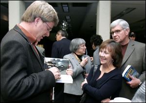 Kathie and Joe Myers of Sylvania, right, get their travel books
autographed by author Rick Steves prior to his talk.
