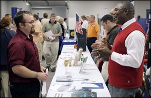 Cameron Volkman, left, of Delta discusses job opportunities with Bobby Green of Western & Southern Financial Group.