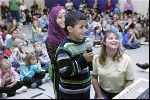 Lozah Alomari, 8, and her brother, Mohamed Alomari, originally from Yemen, ask questions through a video link with Matthew Heller, a Monroe man who is a Peace Corps volunteer in Morocco. Their teacher, Angela Sneider, watches the exchange.