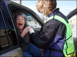 ROV flushot14p 2  Lisa Dutton/ The Toledo Blade   MaumeeOH 11/13/2008 left--Rose Hall of Holland,OH.reacts to getting a flu shot from Lucas County Health Department employee Mary Sheehy (cq) during the drive up flu clinic at Lucas County Recreation Center, 2901 Key St., Maumee