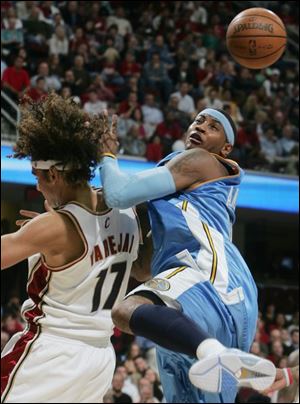 The Cavaliers  Anderson Varejao gets tangled up with Carmelo
Anthony while battling for a rebound last night in Cleveland.
