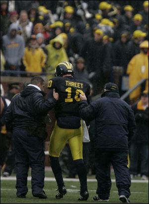 Michigan s Steven Threet is helped from the field after sustaining head and knee injuries during the second half.