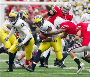 Brandon Minor (4) finds it heavy going through Ohio State's line. He led Michigan's season with 533 yards and nine TDs.
