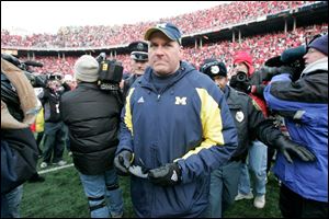 Michigan coach Rich Rodriguez walks off the field after losing the final game to Ohio State to finish the season 3-9.
