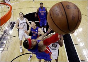 The Pistons' Allen Iverson makes a reverse layup last night against the Spurs. He shared team honors with 19 points.
