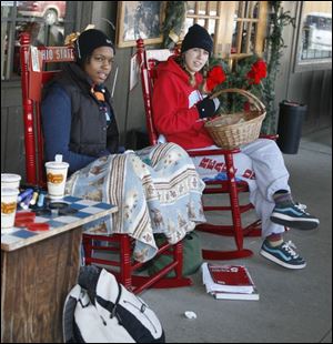 Kalia Blanchard, left, of Central Catholic and Alex Guyton of Bowsher try to stay warm at the Cracker Barrel restaurant.
