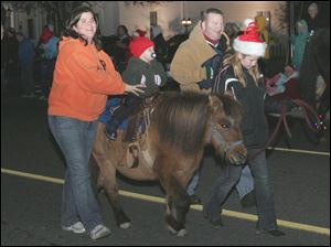 NBRW lights04  Kandice (cq) jarrell, left, keeps Emmett Jarrell, 17 months, on Morgan, while her husband James Jarrell, third from left, walks and Mya (cq) Grines, 10, leads Morgan. They are from Morenci, Michigan. Archbold's 10th annual holiday parade, the Parade of Lights, in Archbold, Ohio on November 28, 2008. The parade will be held Nov. 28 at 6:30 p.m. The parade will feature floats, the high school marching band, a horsedrawn wagon. Every entry must feature lights. The Blade/Jetta Fraser