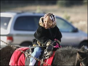 NBRN matthes04p Aaniya (cq) Jordan, 3, of Detroit, on a pony from Lynda's (cq) Pony Rides.  25th annual Christmas tree festival at Matthes Evergreen Farm in Ida, Michigan, on November 29, 2008.  The Blade/Jetta Fraser
