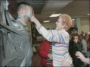 NBRE duct04p    11/25/2008     Blade Photo/Lori King  Assistant principal Pat Murtha gets a pie in the face by longtime Rossford High School secretary Miss Anita Shufritz, during fundraiser for Make-a-Wish sponsored by DECA at Rossford, OH. She has worked for Rossford High School for 50 years.