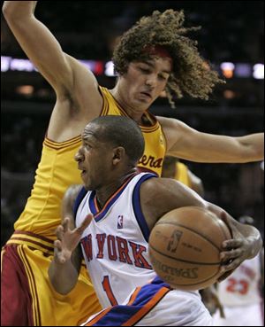 New York's Chris Duhon tries to drive past Cavaliers defender Anderson Varejao last night at Quicken Loans Arena.