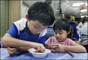 Slug: NBRN crafts04p C                                      The Blade/Jeremy Wadsworth  Date: 11/24/08  Caption: Austin Ausmus, 8, and his sister Alexandria, 8, of Summerfield, Mich., make  Christmas ornaments Monday, 11/24/08, at the Summerfield-Petersburg Library in Petersburg, Mich.