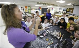Art teacher Cynthia Bodziak talks to fourth graders on making animals out of clay during class at Ottawa Hills Elementary. 